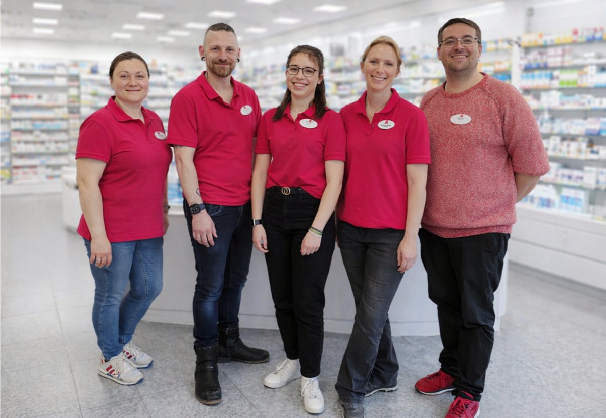 Team der Rochus-Apotheke in Sundern im Verkaufsraum mit Arzneimittelregalen im Hintergrund.